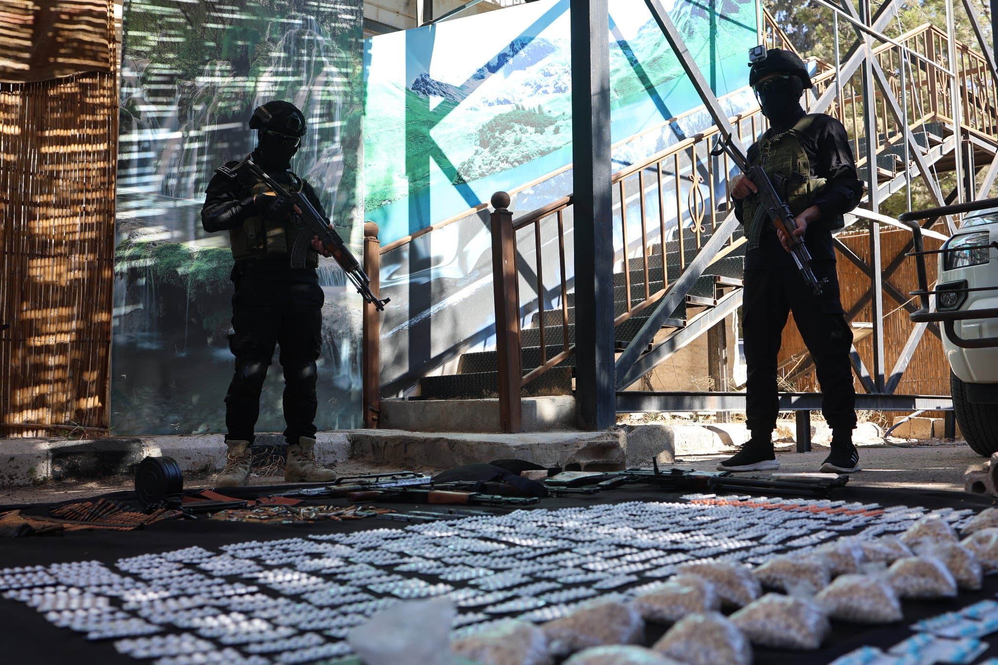 Syria’s anti-narcotics directorate members stand in front of a seized pile of Captagon pills in Daraa province, Syria on July 3, 2026. Photo: Syria’s anti-narcotics directorate