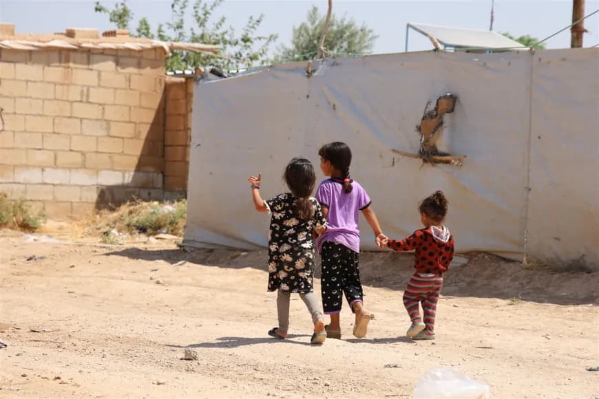 Three children strolling in a camp in Hasaka hosting IDPs from Sare Kani. Photo: ANHA