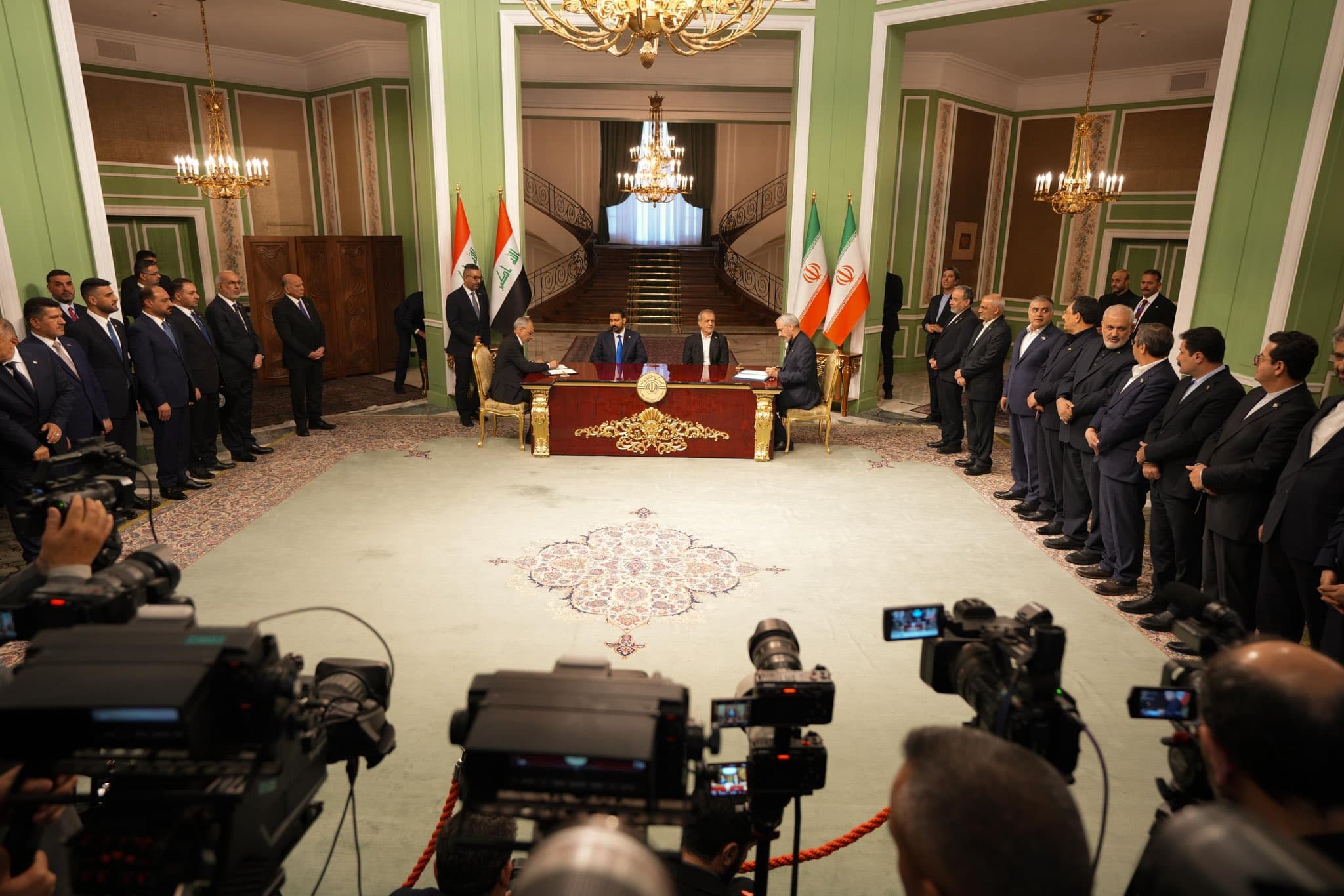 Iraqi Prime Minister Ali al-Zaidi and Iranian President Masoud Pezeshkian in Tehran overseeing the signing a couple of agreements surrounded by their delegations on July 23, 2026. Photo: Iraqi PMO
