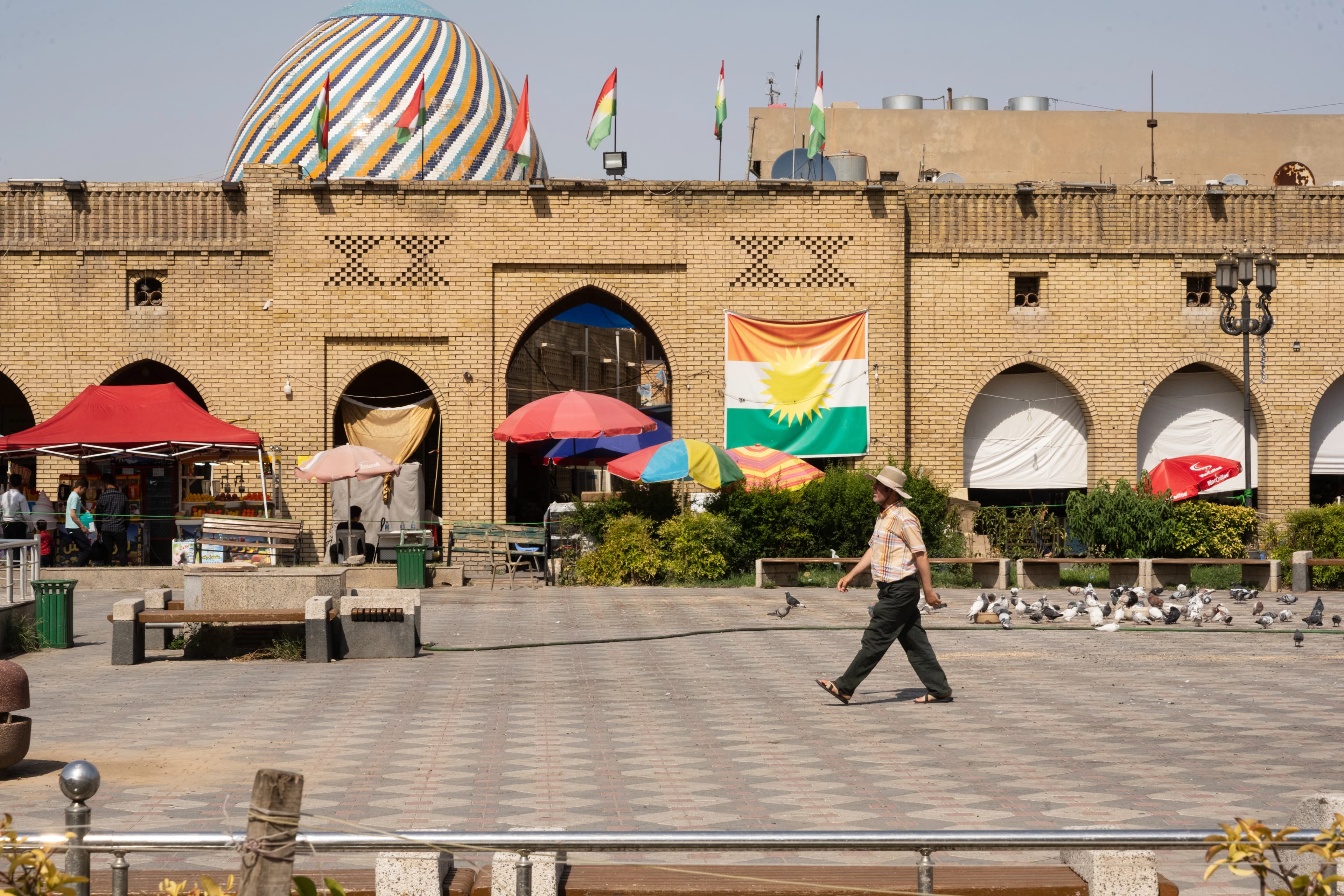وەرزی هاوینە و هاونیشتمانییەک لەنێو پارکی شار لە هەولێر کڵاوی لەسەر ناوە لە گەرما. وێنە: بڵند تاهیر - رووداو