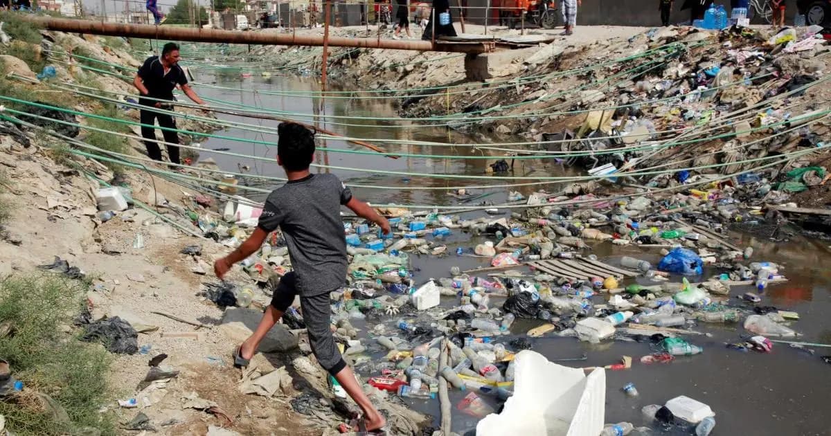 Children playing in a river full of waste in central Basra province. Photo: Reuters Agency