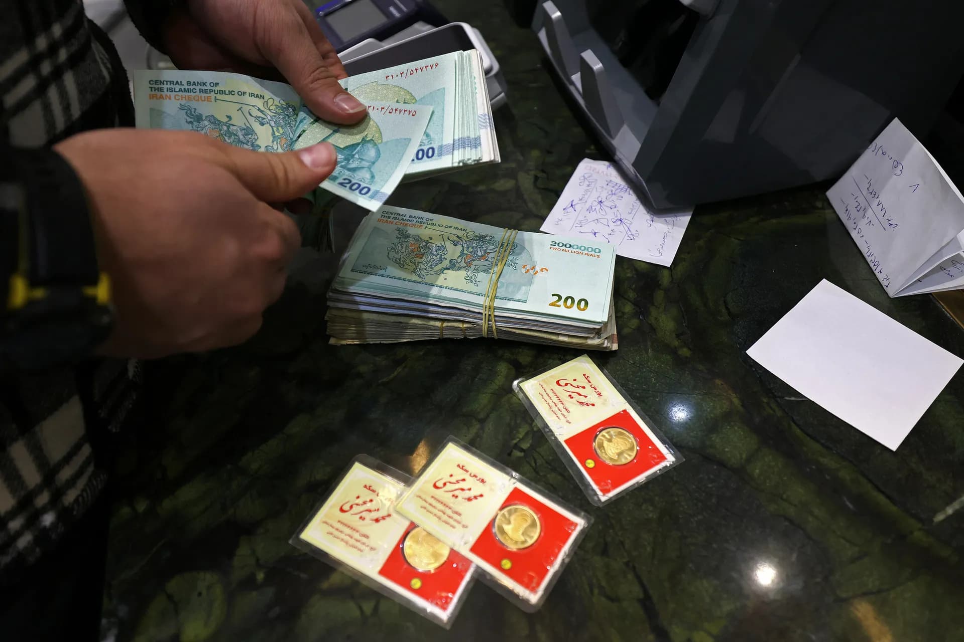 پیاوێک ریاڵی ئێرانی دەژمێرێت لە کاتی کڕینی لیرەی زێڕ لە دوکانێک لە تاران لە 28ی کانوونی دووەم. وێنە: عەتا کەنارە/ئەی ئێف پی لە رێگەی گێتی ئیمەیجز