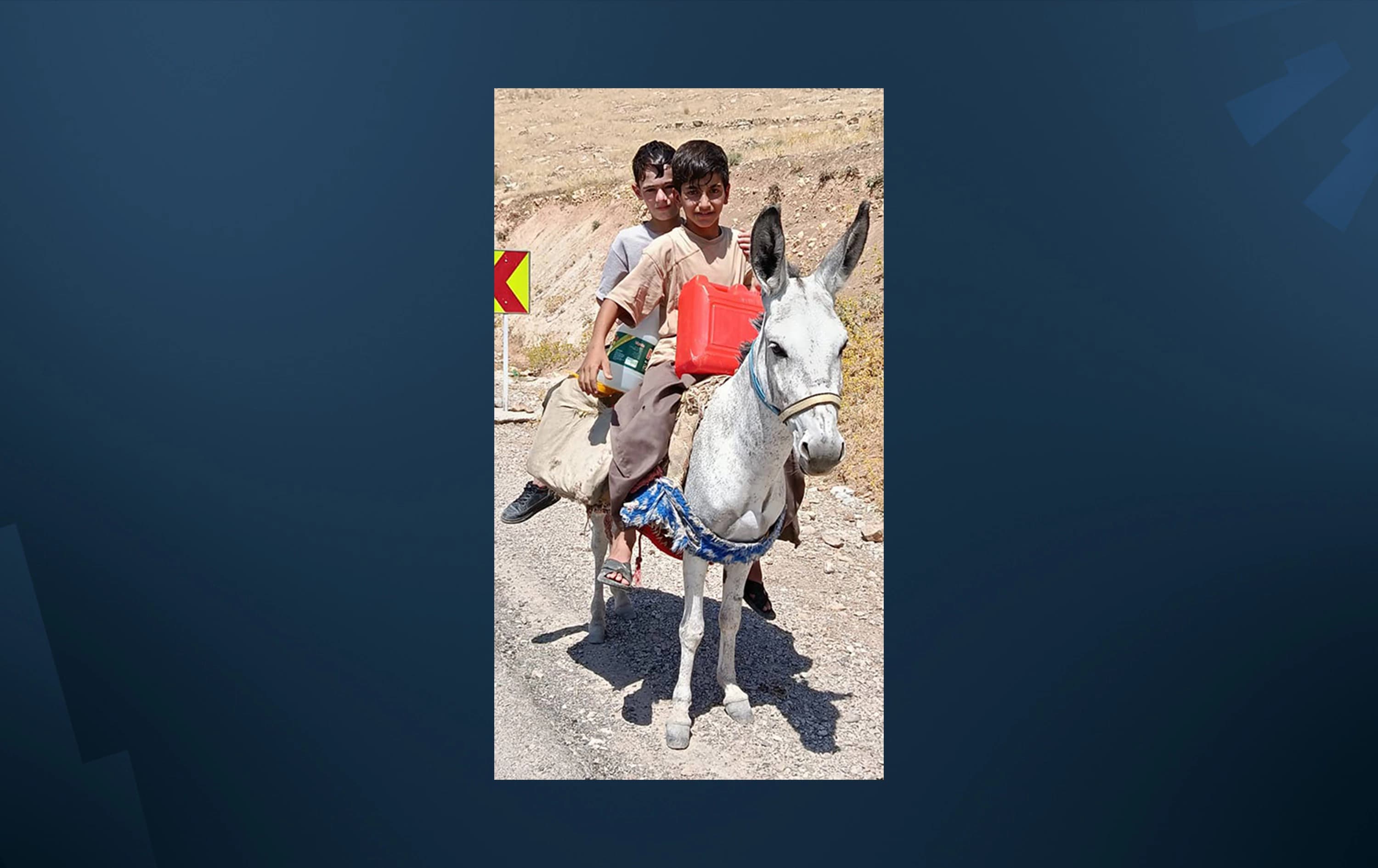 دوو منداڵی گوندی داری زەنگەنە لە کرماشان بە سواری گوێدرێژ ئاو دەهێننەوە. وێنەکە تایبەت بۆ رووداو نێردراوە.
