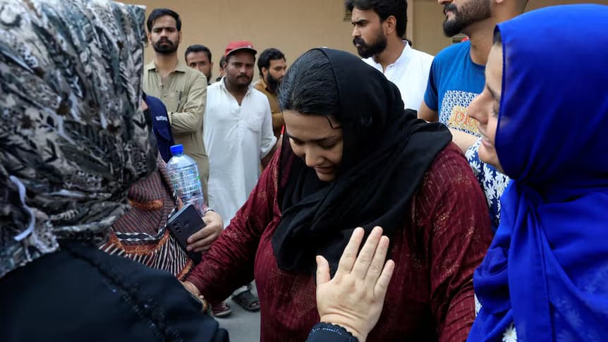 Dayîk li ser dergûşên xwe digirîn / Wêne: Reuters: Akhtar Soomro