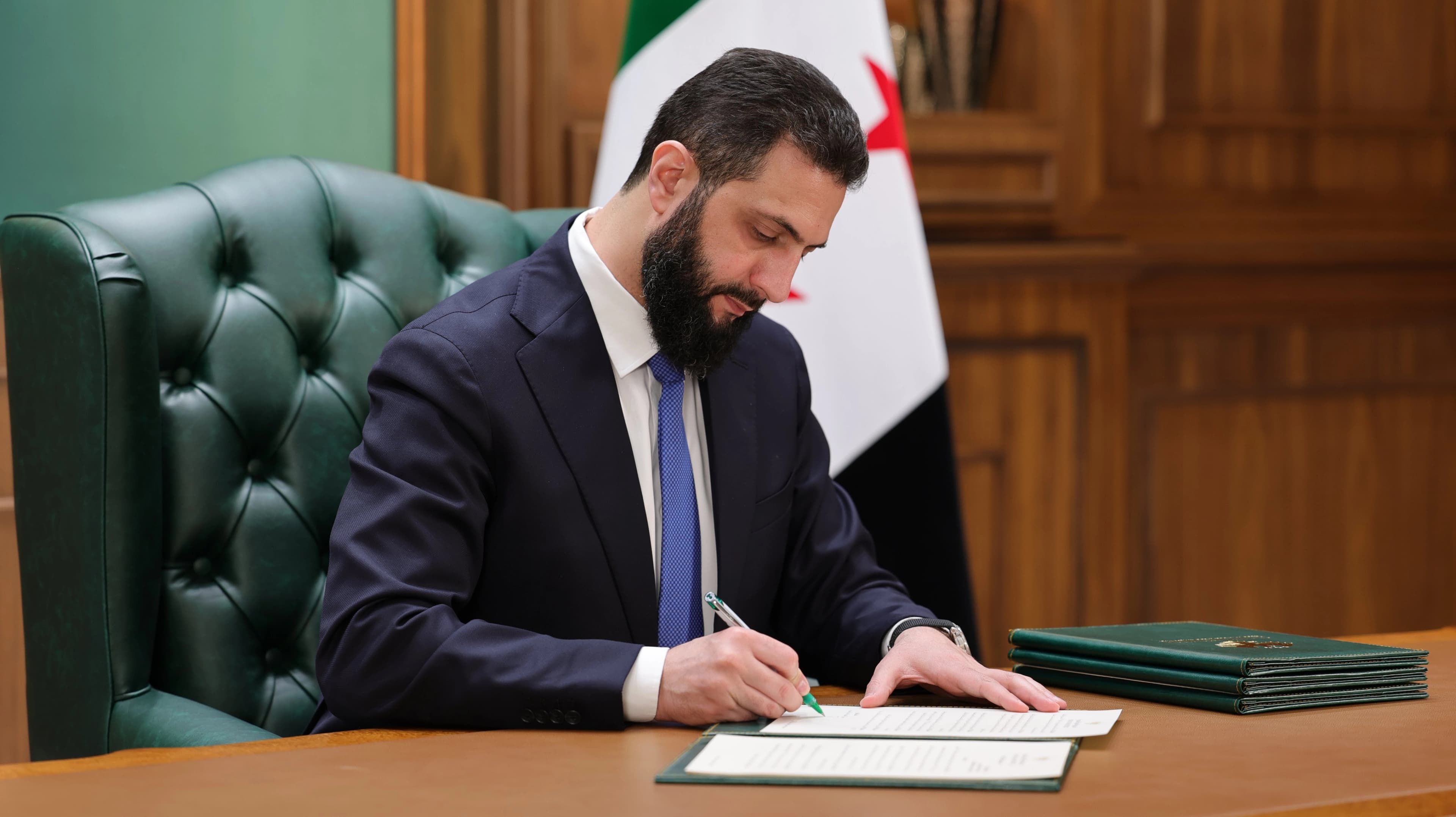 Syrian interim President Ahmed al-Sharaa signs an official document on May 25, 2026. Photo: AH_AlSharaa/X