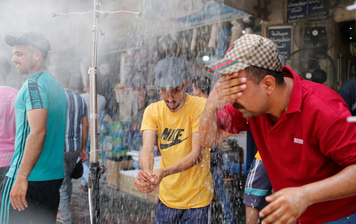 رجال في بغداد يغسلون وجوههم بالمياه للتخفيف من درجة حرارة أجسادهم - ارشيف