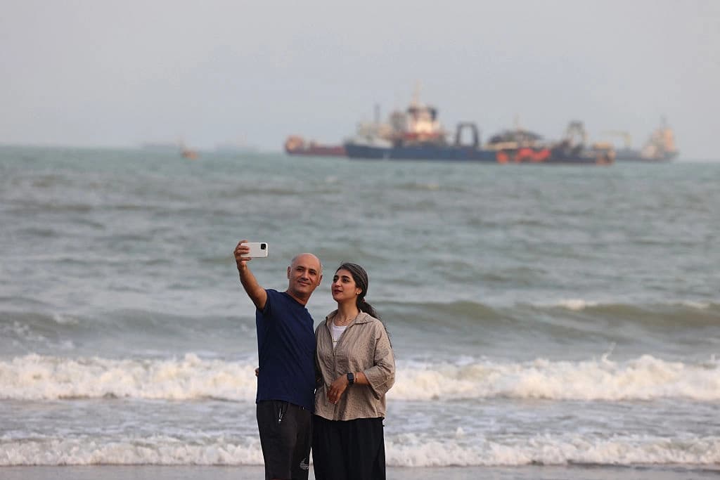Iranians take a selfie along the shoreline as vessels are seen in the Strait of Hormuz off Bandar Abbas, in southern Iran on August 10, 2026. Photo: AFP