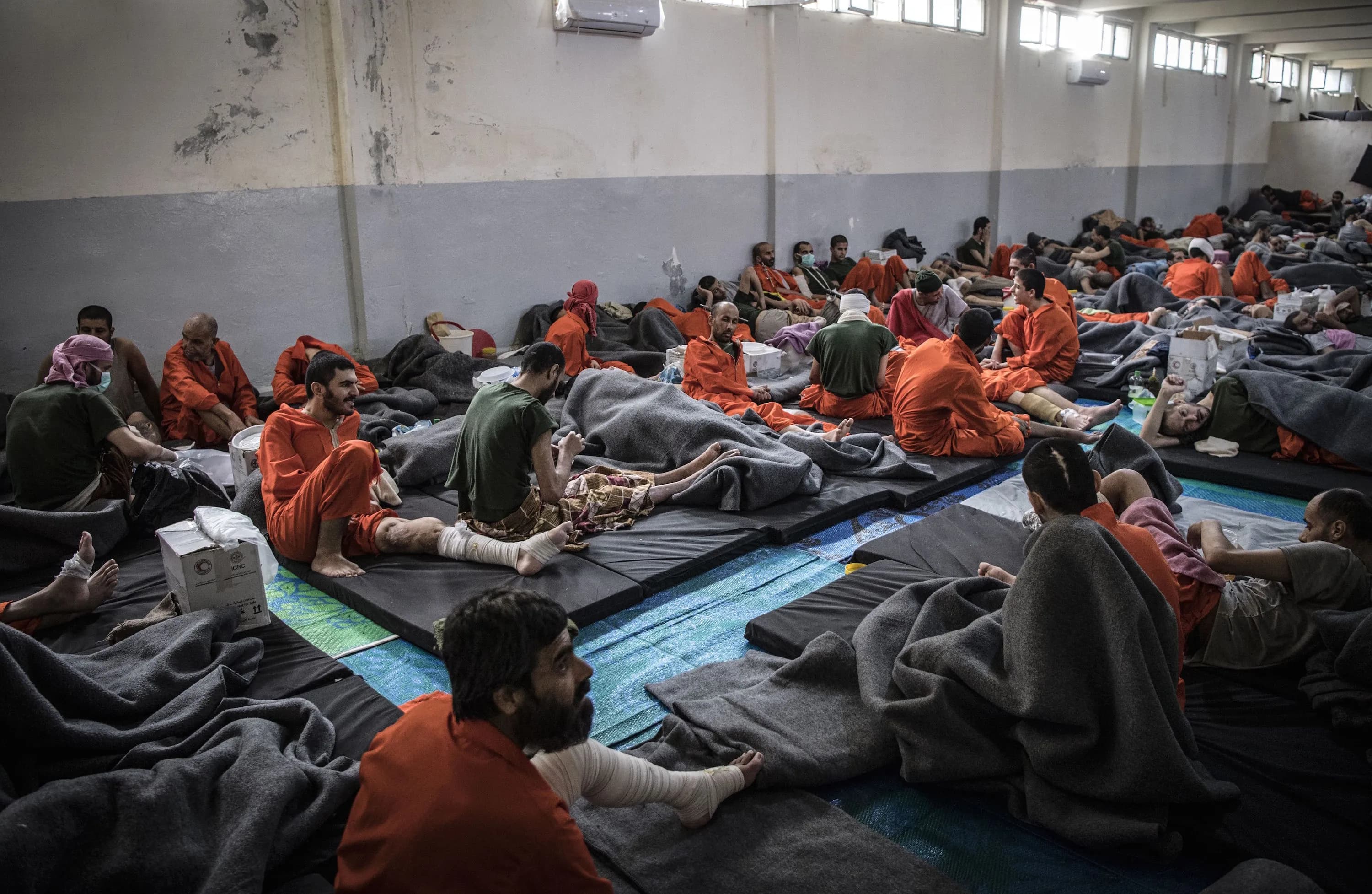 Alleged Islamic State (ISIS) members sit on the floor in a prison in northeastern Syria. File Photo: AFP