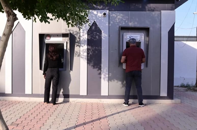 موظفان أثناء استلام راتبيهما من صرّافين آليين/ بلند طاهر - رووداو