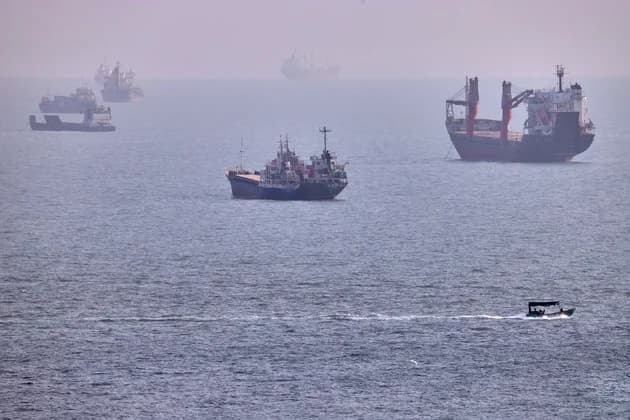 A small boat sails past cargo ships and other commercial vessels anchored in the Strait of Hormuz off Bandar Abbas, Iran, Wednesday, Aug. 5, 2026. Photo: AP