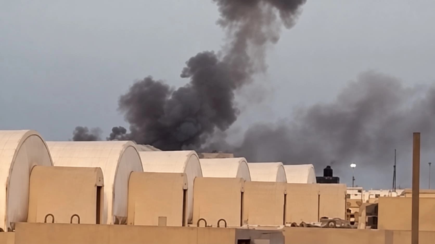 دووکەڵ لە کەمپ بیوورینگ بەرز دەبێتەوە دوای هێرشی درۆنیی ئێران. وێنە لە ڤیدیۆیەکی CBS News وەرگیراوە.