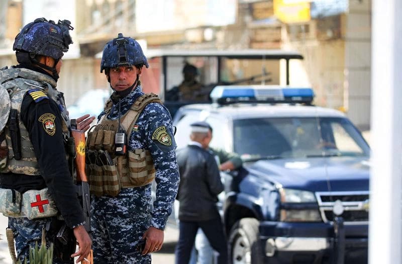Members of the Iraqi federal police forces stand guard at a checkpoint in a street in the capital Baghdad on January 29, 2021. (AFP)