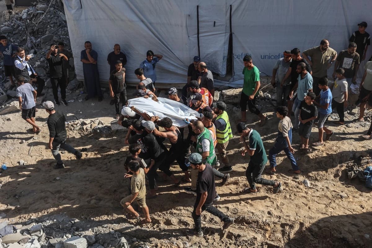 خۆبەخشان و تیمەکانی فریاگوزاری تەرمی قوربانییەک هەڵدەگرن کە لەژێر داروپەردووی باڵەخانەیەکی داڕماودا لە گەڕەکی تەل ئەلهەوا لە شاری غەززە دۆزراوەتەوە، 16ـی ئەیلوولی 2026. وێنە: AFP