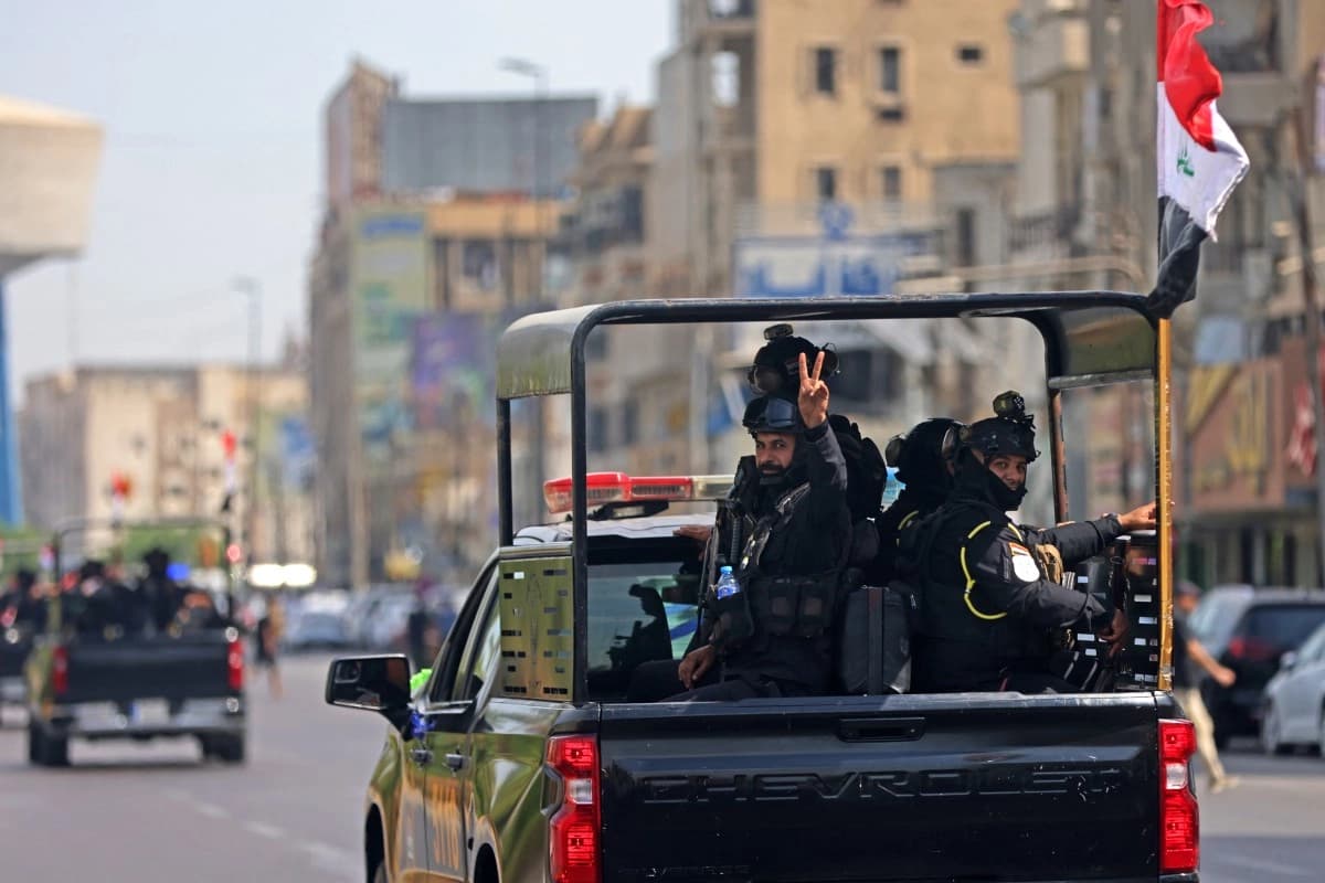 يرفع أفراد من قوات الأمن العراقية شارة النصر خلال عرض عسكري في بغداد-AFP
