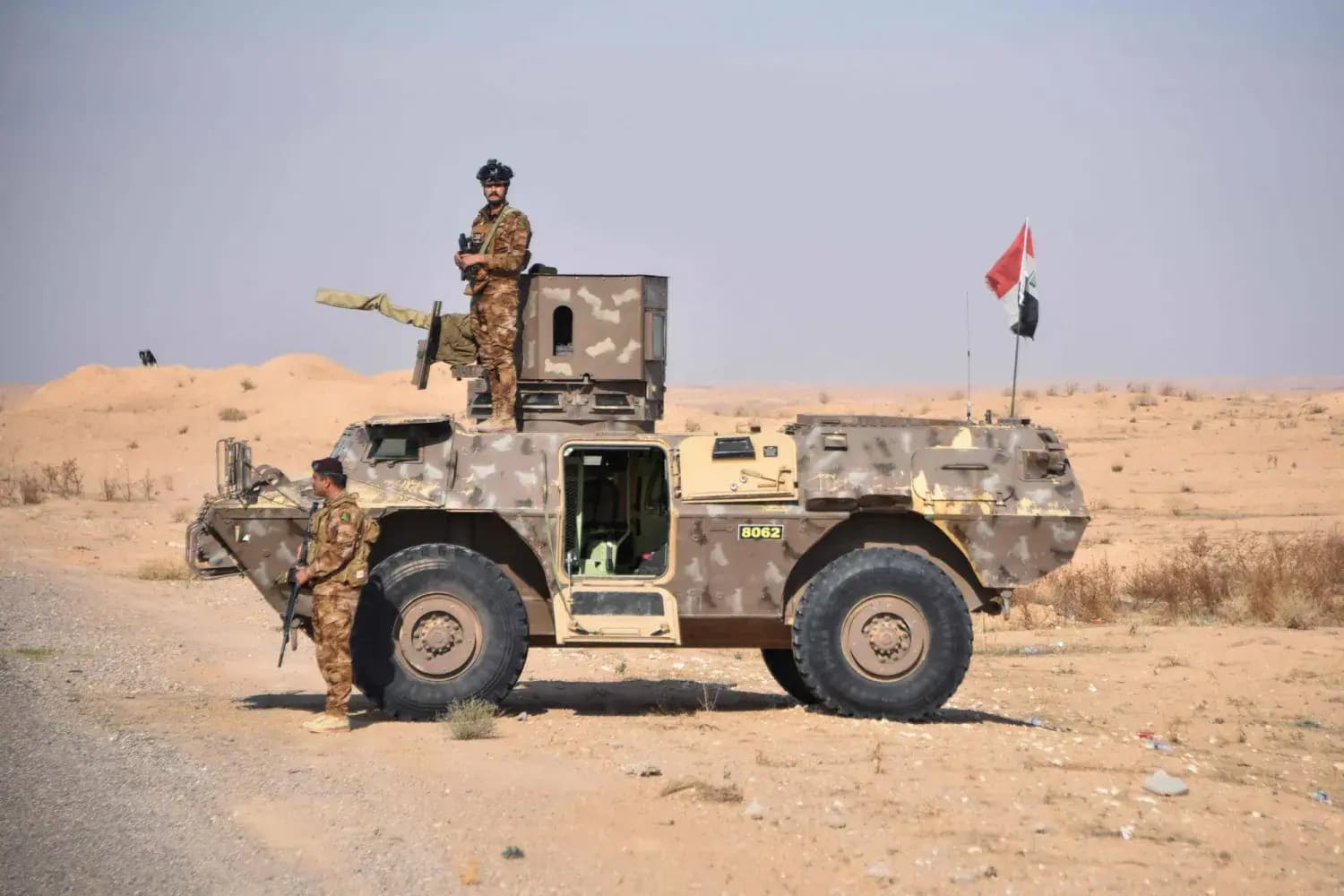 ثلاثة جنود من الجيش العراقي ومركبة عسكرية