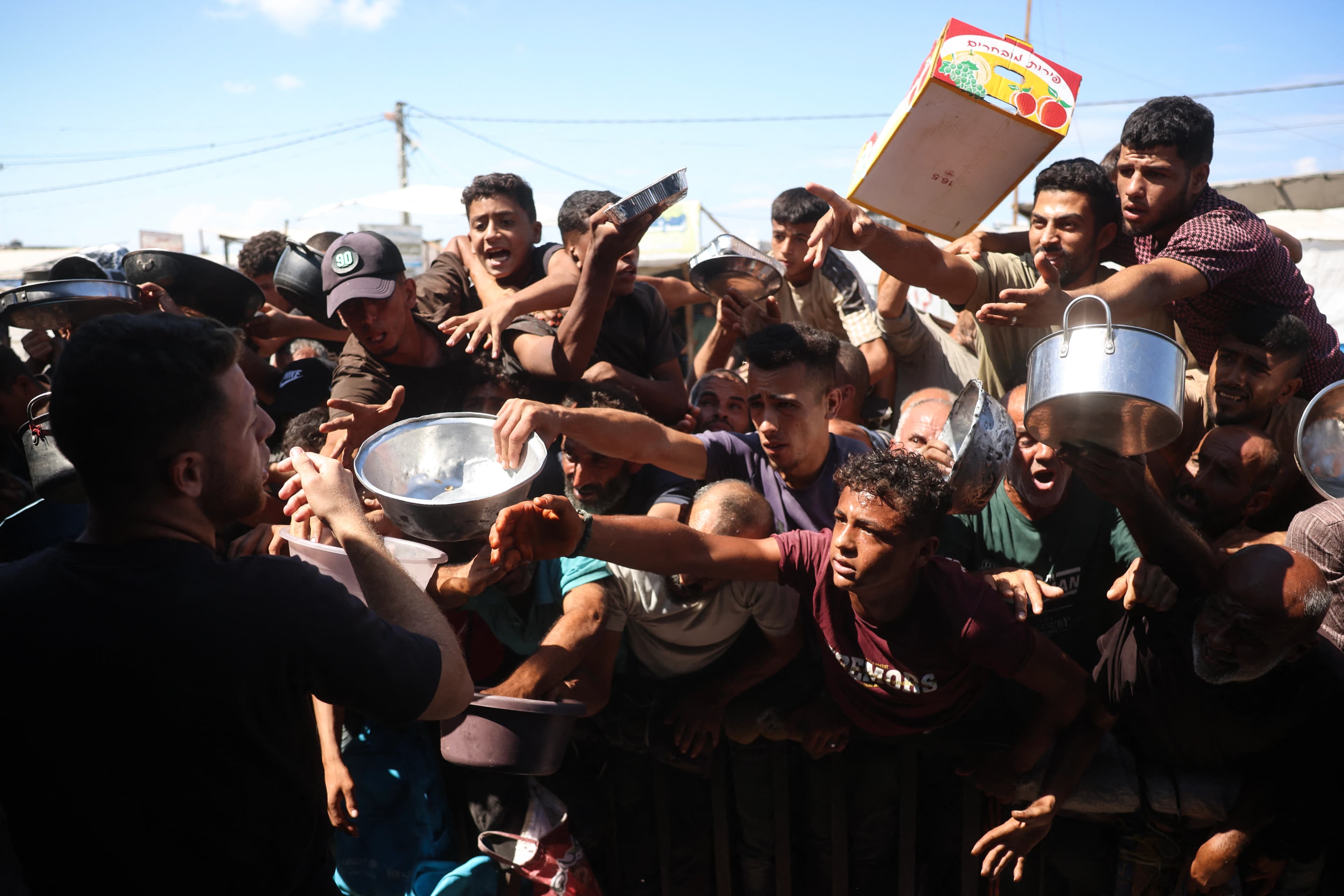 ژمارەیەک هاووڵاتیی فەلەستینی لە نۆرەی وەرگرتنی خواردنن لە شاری خان یونس. وێنە: AFP