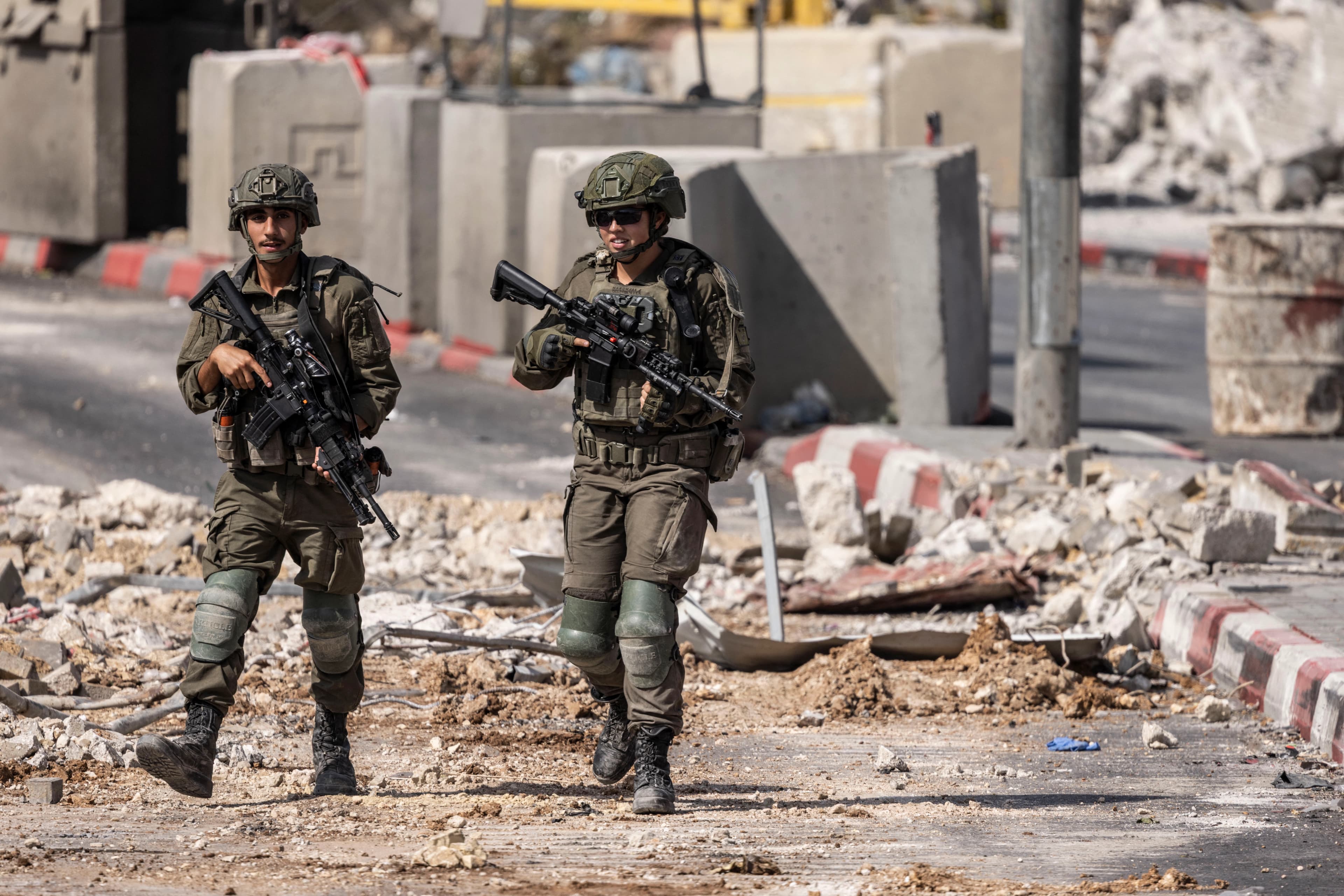 جنديان إسرائيليان يقومان بدورية عند حاجز التفتيش الشمالي في الخليل-AFP